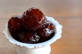 Sweet Jujube or Chinese red date in syrup in white Thai style cup on wood table and space for write wording