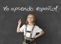 Sweet junior blond schoolgirl smiling happy in children learning spanish language and education concept