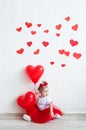 Sweet kid with red heart. Happy little girl with red balloon at a blank brick wall. Wedding, Valentine concept
