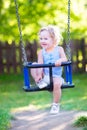 Sweet laughing toddler girl swinging ride on playground Royalty Free Stock Photo