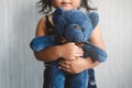 Sweet little asian girl hugging her favorite toy teddy bear