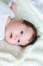 Sweet little baby daughter on white woolen blanket