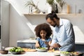 Sweet little Black girl helping dad to prepare dinner Royalty Free Stock Photo
