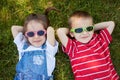 Sweet little boy and girl, wearing glasses, smiling, laying on t Royalty Free Stock Photo