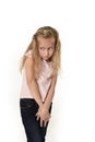 Sweet little child girl with beautiful blonde hair in casual clothes looking shy and timid as if scared Royalty Free Stock Photo