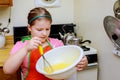 Sweet little cute girl is learning how to make a cake, in the home kitchenlearns to cook a meal in the kitchen Royalty Free Stock Photo