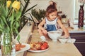 Sweet little cute girl learns to cook a meal in the kitchen. Royalty Free Stock Photo