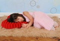 Sweet little girl asleep on heart shaped pillow Royalty Free Stock Photo