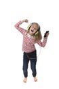 sweet little girl with blonde hair listening to music with headphones and mobile phone singing and dancing happy Royalty Free Stock Photo