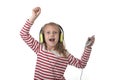 Sweet little girl with blonde hair listening to music with headphones and mobile phone singing and dancing happy Royalty Free Stock Photo