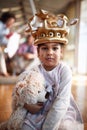 A sweet little girl with a crown and a teddy posing for a photo while sitting on the floor and playing at home. Family, together, Royalty Free Stock Photo