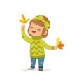 Sweet little girl in in a green sweater holding colorful maple leaves, cute kid enjoying fall, autumn kids activity Royalty Free Stock Photo