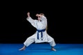 Sweet little girl in martial arts practice like karate kid alone isolated on black background