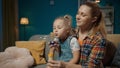 A sweet little girl sits on her mom's lap and blows soap bubbles. Mom and cute little daughter spending time Royalty Free Stock Photo