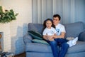 Sweet little girl together with beautiful young dad sitting on sofa in living room at home in evening. Happy family concept. Love Royalty Free Stock Photo