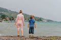 Little kids playing by the lake on a very windy day under summer rain Royalty Free Stock Photo