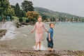 Little kids playing by the lake on a very windy day under summer rain Royalty Free Stock Photo