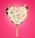 Sweet Lolipop in Heart form of whipped cream with sweets, jellies, heart front view. Crazy freakshake food trend. Front