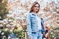 Young girl standing on Magnolia blossoming flowers tree Royalty Free Stock Photo