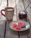 Sweet lunch with cranberry marshmallow and marmalade, green tea in a large ceramic mug and a glass jar with cherry jam Royalty Free Stock Photo