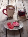 Sweet lunch with cranberry marshmallow and marmalade, green tea in a large ceramic mug and a glass jar with cherry jam Royalty Free Stock Photo