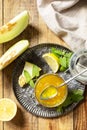 Sweet melon and citrus jam or jelly in small glass jar with fresh melon slices on wooden rustic table. Homemade preserve. View Royalty Free Stock Photo