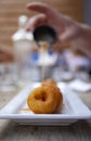 Sweet mini donuts on a white tray with maple syrup and loads of sugar