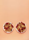 Sweet mini pancakes with red and black currants on white plates on a peach background Royalty Free Stock Photo