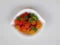 Sweet mixed color jelly candy in a white bowl against white background