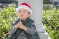 Sweet Mixed Race Boy Wearing Santa Hat Eating Candy Cane Royalty Free Stock Photo