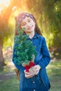 Sweet Mixed Race Young Girl Holding Small Christmas Tree Outdoors Royalty Free Stock Photo