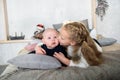 Sweet moment between a big sister and her baby brother. The sister is kissing his cheek. Love sisters. parental care and