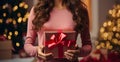 Sweet moment Hispanic girl back view holding a gift near the Christmas tree