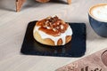 Close up view on fresh homemade  cinnabon bun with toping caramel and nuts. Royalty Free Stock Photo