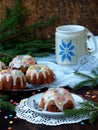 Sweet muffins decorated fondant, multicolored sprinkles. Cupcakes on dark background with spruce branches. Christmas and New Year