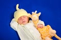 Sweet newborn baby boy sleeping on a blue blanket with little toy Royalty Free Stock Photo