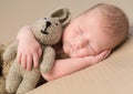 Sweet newborn baby embracing toy-hare