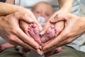 sweet newborn family forming Baby feet heart baby's feet in mom and dad parent hands selective color Royalty Free Stock Photo