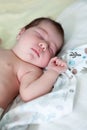 Sweet one month old newborn baby sleeping on her back in her crib, hand up Royalty Free Stock Photo