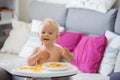 Sweet one years old baby boy, eating pasta at home, kid eats spaghetti Royalty Free Stock Photo