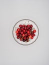 Sweet organic red cherries with water droplets in a glass bowl isolated on white background