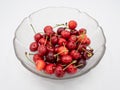 Sweet organic red cherries with water droplets in a glass bowl isolated on white background Royalty Free Stock Photo
