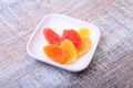 Sweet papaya dried slices in white plate on wood background. selective focus.