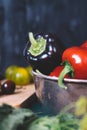 Sweet pepper in a round metal bowl and a bunch of basil in white textiles and wooden table from old vintage boards, Royalty Free Stock Photo