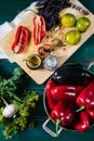 Sweet pepper in a round metal bowl and a bunch of basil in white textiles and wooden table from old vintage boards Royalty Free Stock Photo