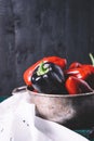 Sweet pepper in a round metal bowl and a bunch of basil in white textiles and wooden table from old vintage boards Royalty Free Stock Photo