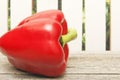 Sweet pepper on wooden table and on fence background closeup. Side view. Copy space Royalty Free Stock Photo