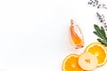 Sweet perfume with fruit fragrance. Bottle of perfume near apple, orange, lavender on white background top view spac