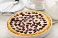 Sweet pie baked with frozen cherries on wooden table. Royalty Free Stock Photo