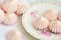 Sweet and pink mini French meringues on a plate